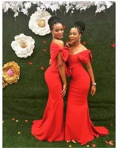 two women in red dresses standing next to each other