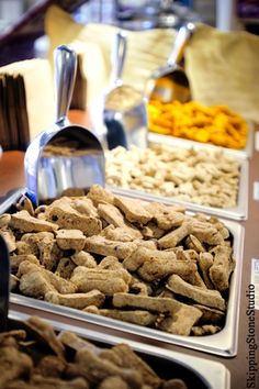 there are many different types of dog food on the buffet table, including meats and biscuits