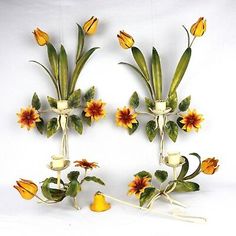 two vases with flowers and leaves are on the wall next to each other in front of a white background