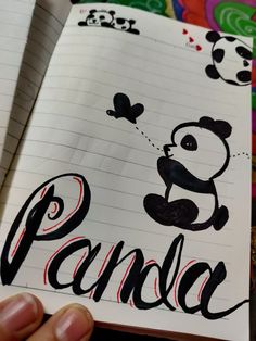 a person holding up a piece of paper with the word panda written in black on it