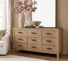 a living room scene with focus on the dresser and large mirror in the corner,