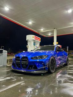 a blue sports car parked at a gas station