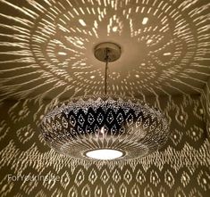 a chandelier hanging from the ceiling in a room with intricate patterns on it