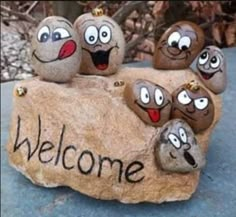 some rocks with faces painted on them that say welcome