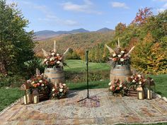 two wine barrels with floral arrangements sit on an outdoor blanket