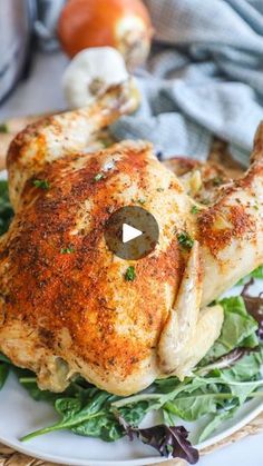 a whole chicken sitting on top of a white plate next to vegetables and an apple