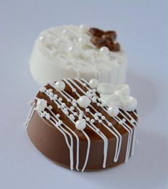 two pieces of chocolate with white frosting on them