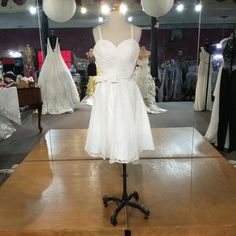 a white dress is on display in a clothing store with other mannequins