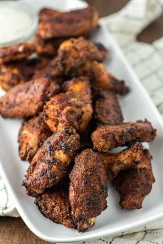 crispy smoked chicken wings on a white plate with text overlay that says crispy smoked chicken wings