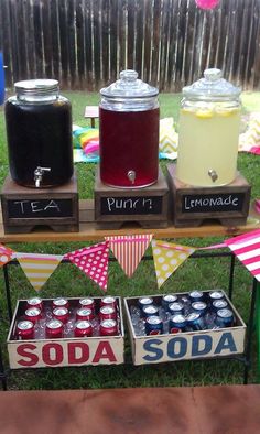 an outdoor table with sodas and lemonade on it