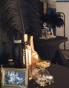 a table topped with lots of gold and black items on top of a table covered in feathers