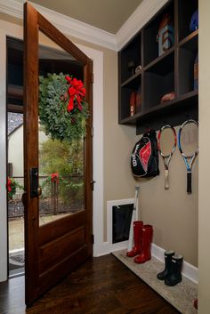 the entryway is decorated for christmas with wreath and tennis rackets