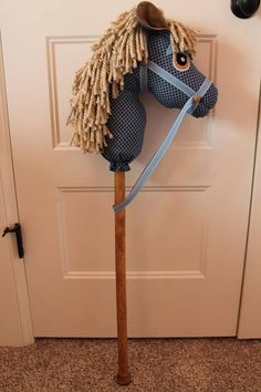 a wooden horse head mounted to the side of a door with a blue ribbon on it