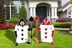 two lawn decorations with hearts and spades on them in front of a house decorated for halloween