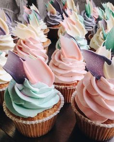 there are many cupcakes with frosting on the top one is pink and blue