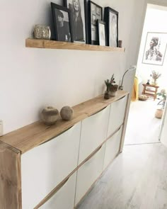 a white and wooden shelf with pictures on it