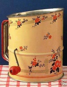 a red and white checkered table cloth with an old fashioned tin can holding a cherry