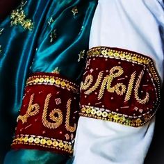 closeup of two red and white cuffs with gold lettering on them that spell out the word blg