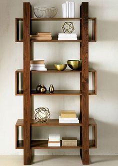 a wooden shelf with books and bowls on it