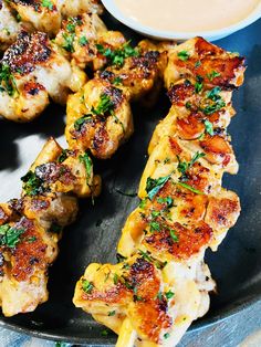 chicken skewers on a plate with dipping sauce