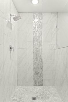 a white tiled shower stall with glass doors