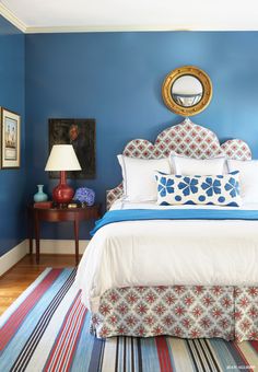 a bedroom with blue walls and white bedding