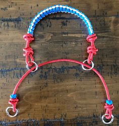 a red, white and blue horse bridle on a wooden table