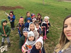 a group of children are standing in the grass