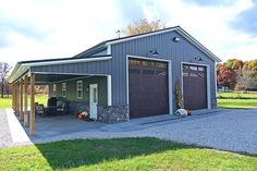 a two car garage with an attached carport in the middle of a grassy area