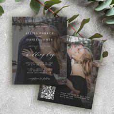 two wedding cards with the same photo on them, next to some greenery and leaves