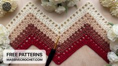 a crocheted triangle is shown with flowers around it