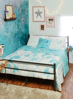 a bedroom with blue walls and white bedding in the center is decorated with string lights