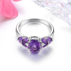 Elegant Vintage 2.5 Carat Natural Amethyst and Silver Ring with Classic Design This sterling silver ring embodies a luxurious and classic style, featuring a stunning deep purple 2.5 carat natural Amethyst gemstone, reminiscent of vintage elegance. Timeless Craftsmanship Crafted with precision and sophistication, this ring is a perfect addition to any jewelry collection. Its vintage design makes it suitable for various occasions, from casual outings to formal events. Gemstone Quality Metal: 925 S Elegant Silver Three-stone Gemstones, Elegant Three Stone Silver Gemstones, Elegant Purple Amethyst Open Ring, Elegant Purple Sapphire Ring With Gemstone Accents, Elegant Purple Birthstone Ring With Open Design, Elegant Purple Birthstone Open Ring, White Gold Amethyst Ring With Gemstone Accents, Elegant Amethyst Crystal Ring In White Gold, Elegant White Gold Amethyst Crystal Ring