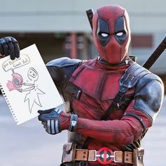 a man dressed as deadpool holding a drawing