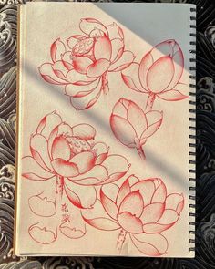 an open notebook with drawings of flowers on it