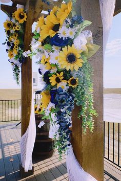 the flowers are hanging from the wooden structure