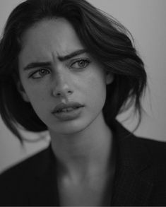 a black and white photo of a woman looking at the camera with an angry look on her face