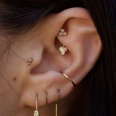 a close up of a person's ear with three different types of piercings