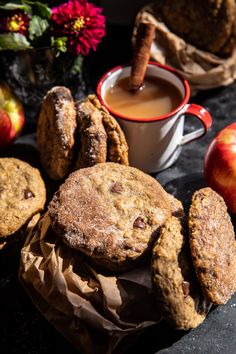 some cookies and apples are next to a cup of coffee