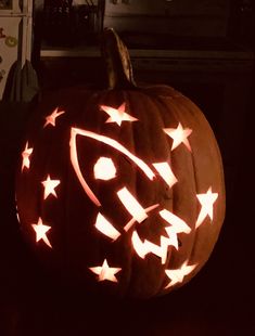 a pumpkin carved to look like a space shuttle with stars on it's side