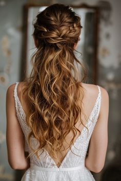 the back of a woman's head with long, curly hair in her wedding dress