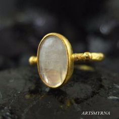 ARTSMYRNA METAL: 925k Silver GEM: Natural Moonstone Diameter Stone Size: 12x10 mm COATING: 24k gold over (We can made a special type of coating for your personal preference ) MATERIEL : 925K Sterling Silver ( Some of my items vermeil gold over silver for looks rich . But i can finish in silver too ) RING SIZE: 6 (your desired size is made) SPECIAL ORDER IS MADE. If you send us a photo of your desired model (you can send your gem.) We can do it for you. We can make any design you want with natura Handmade Gold Moonstone Ring In Sterling Silver, Handmade Mystical Round Moonstone Ring, Mystical Round Handmade Moonstone Ring, Mystical Handmade Round Moonstone Ring, Mystical Handmade Moonstone Ring, Handmade Mystical Moonstone Ring For Anniversary, Oval Hand Forged Moonstone Ring Gift, Artisan Oval Moonstone Ring, Mystical Cabochon Moonstone Ring Gift