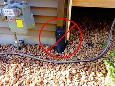 a red circle is in front of an air conditioner on the ground next to rocks