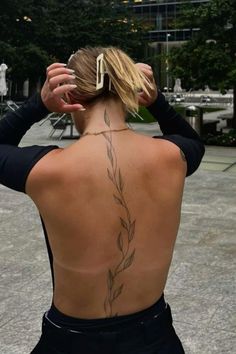 the back of a woman's body with tattoos on her upper and lower back