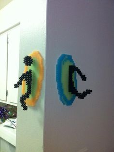 two pieces of art made out of legos are hanging on the wall next to each other