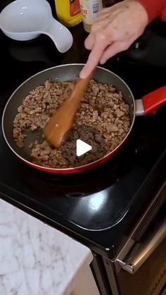 a person cooking food in a pan on the stove