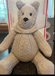 a knitted teddy bear sitting on top of a counter