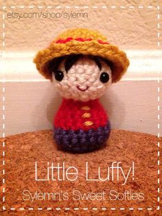 a little stuffed animal wearing a knitted hat on top of a wooden table next to a wall