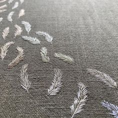 an embroidered fabric with silver leaves on it