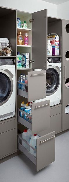 a washer and dryer in a room next to each other with shelves on the wall